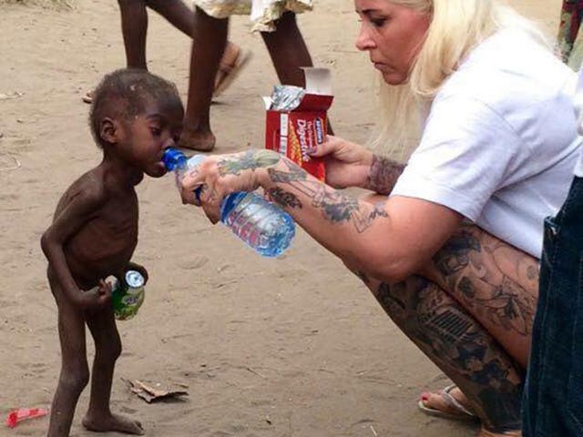 Anja Ringgren Loven gives water to Hope, 2, after finding the emaciated boy wandering the streets