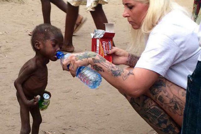 Anja Ringgren Loven gives water to Hope, 2, after finding the emaciated boy wandering the streets
