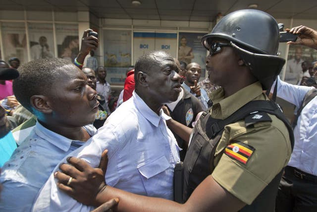 Presidential candidate Kizza Besigye, centre, is held by riot police after attempting to walk with his supporters along a street in Kampala yesterday. The rally was tear-gassed and Mr Besigye arrested