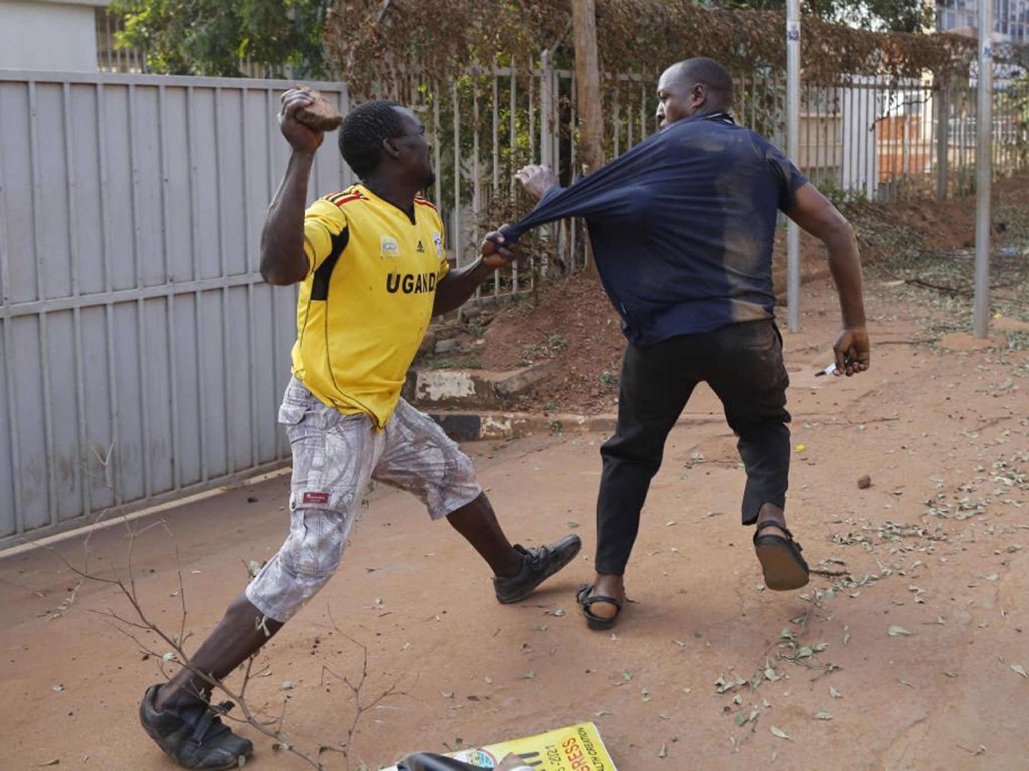 A man is attacked shortly after police fired tear gas at supporters of Kizza Besigye in Kampala