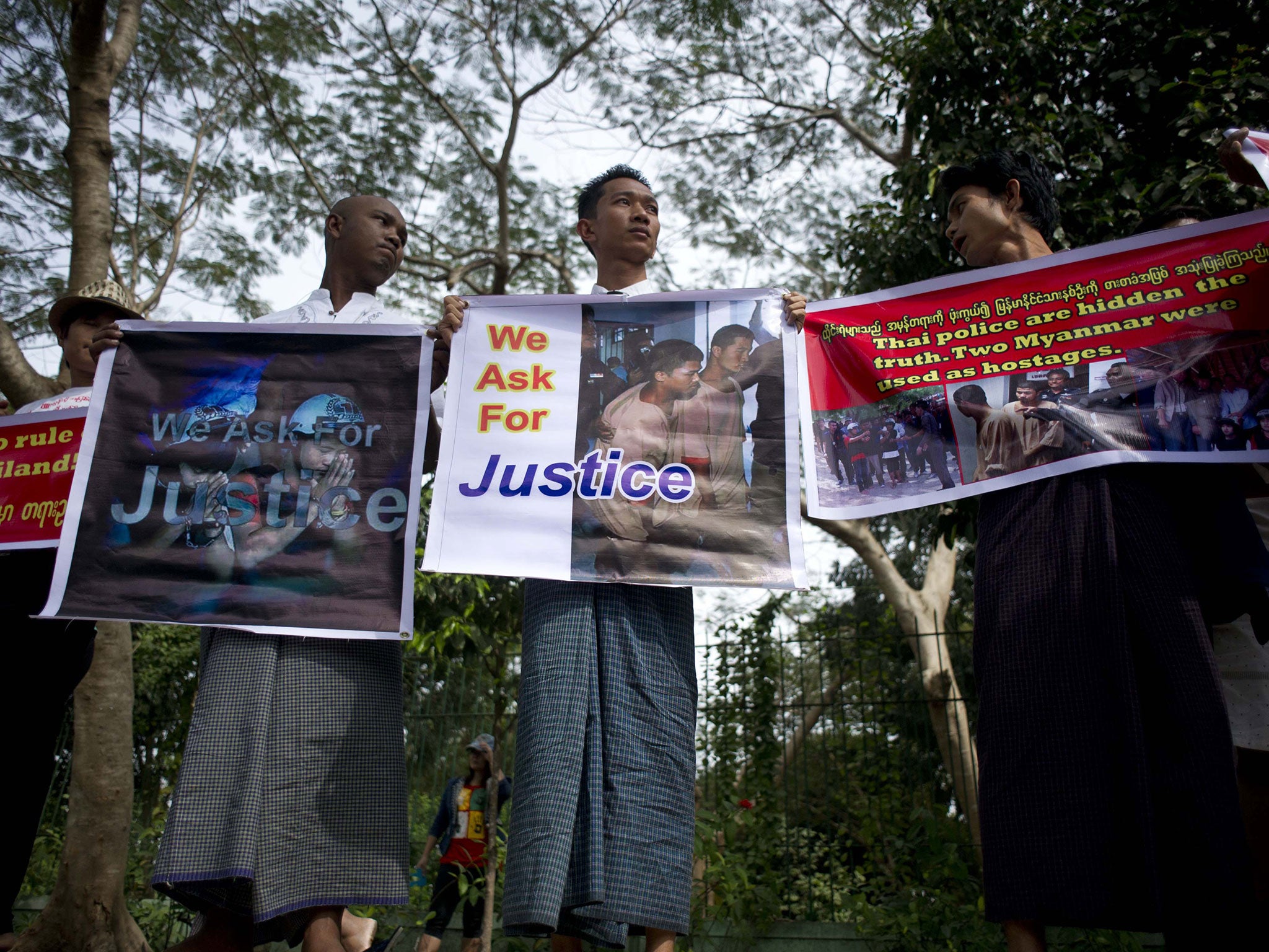 Demonstrators in Myanmar hold placards protesting against the court's verdict sentencing the two migrant workers to death