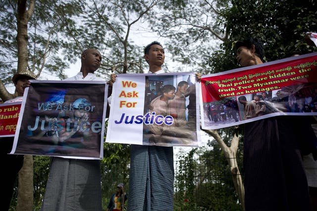 Demonstrators in Myanmar hold placards protesting against the court's verdict sentencing the two migrant workers to death