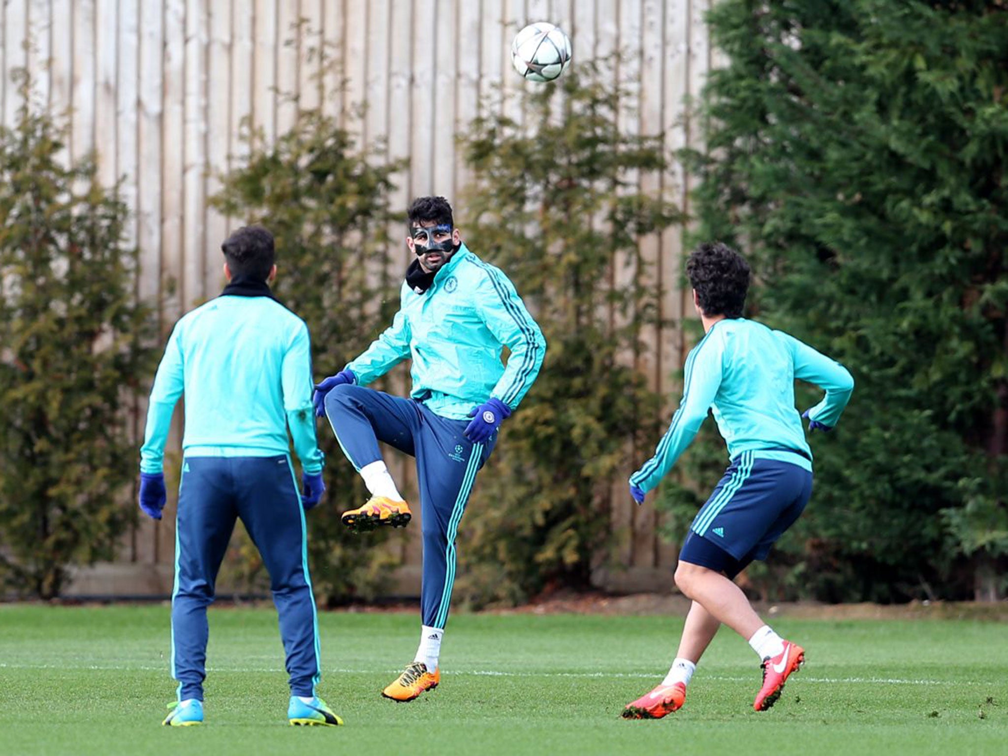 Diego Costa, in a protective mask, practises with team-mates at Chelsea’s training ground