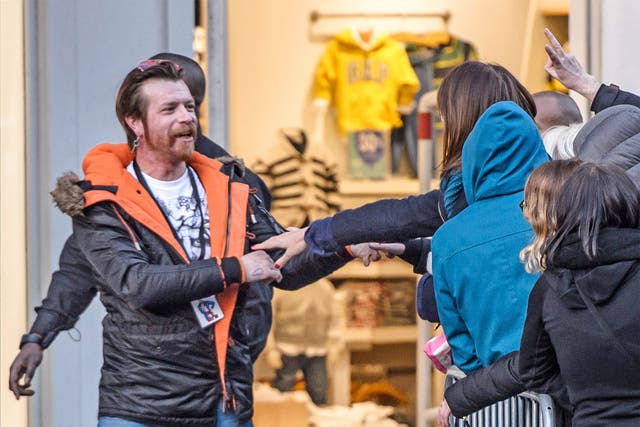 Lead singer of the band 'Eagles of Death Metal' Jesse Hughes holds the hands of a fan as he arrives for a concert at the Olympia music venue in Paris