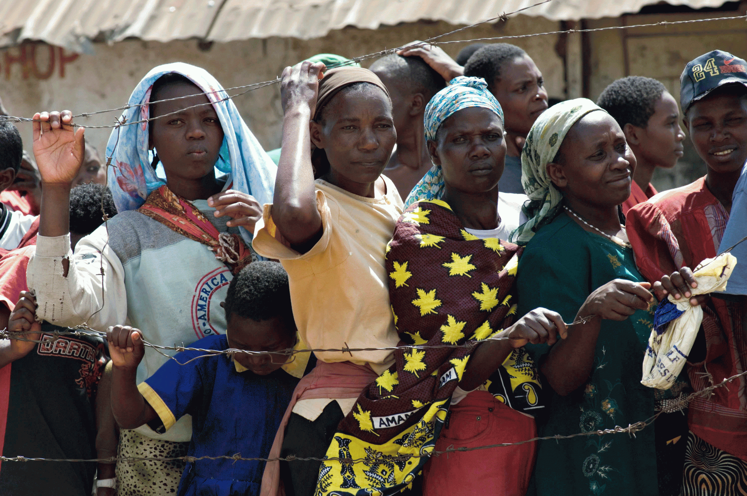 Kenyan woman who have been displaced by the post-election violence queuing for food. A new report says hundreds were raped during that period.