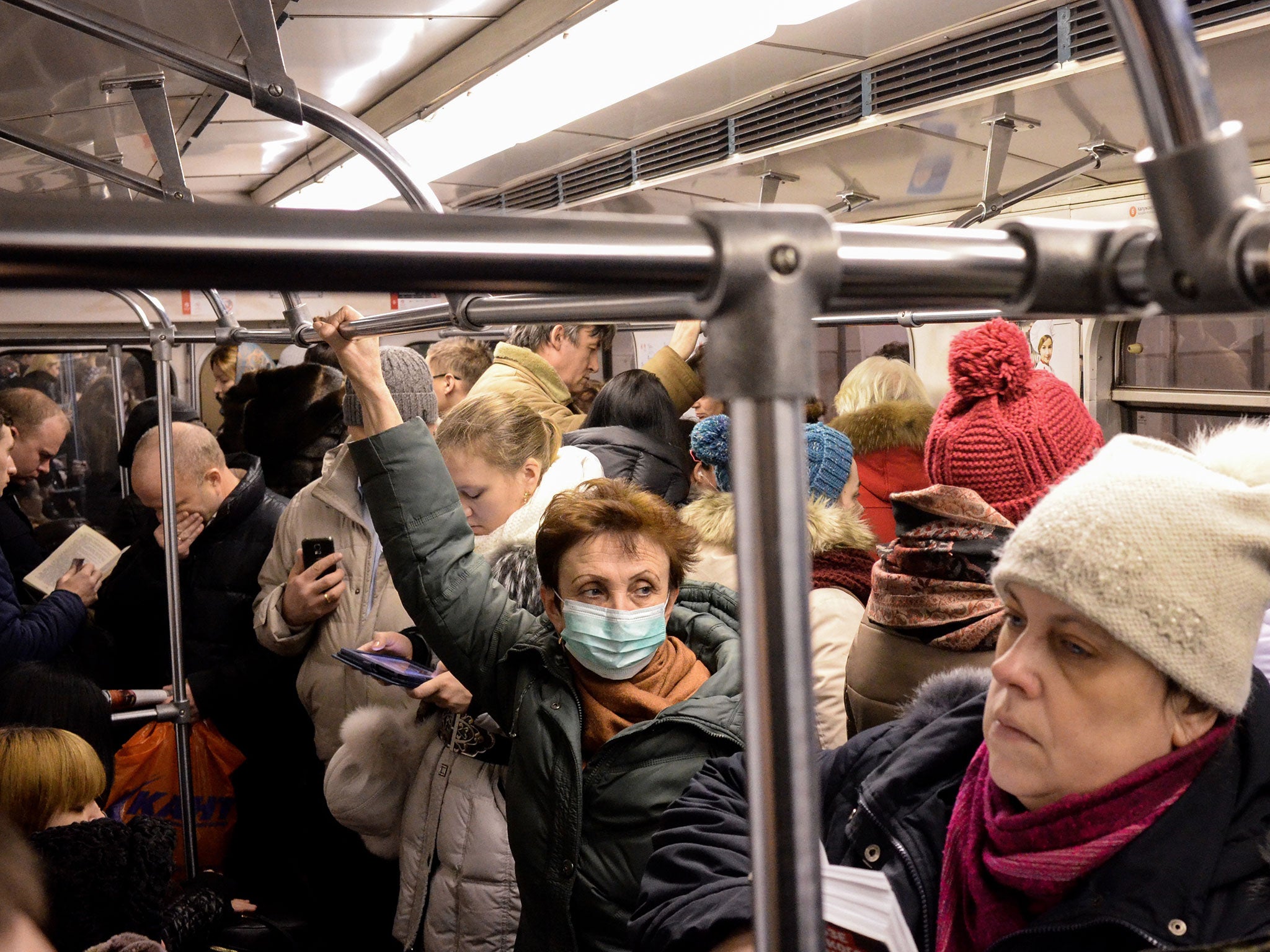A woman wears a face mask while riding inside a train coach in the Moscow Metro, on January 27, 2016. At least 50 people have died of swine flu in Russia since December, according to AFP calculations