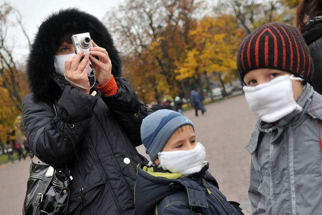 A woman and her children wear masks as they walk in the centre of western Ukrainian city of Lviv on October 30, 2009.