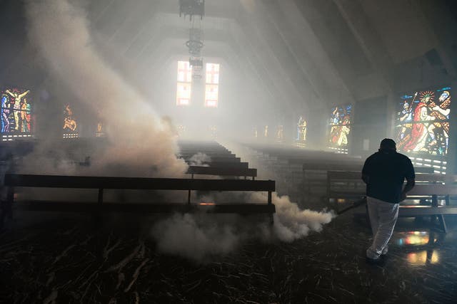A Health Ministry employee fumigates against the Aedes Aegypti mosquito inside a church in Caracas on 5 February, 2016