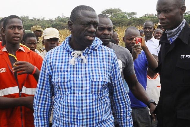 Uganda's Opposition leader Kizza Besigye, center, meets his supporters after casting his vote at a polling station near his country home in Rukungiri, about 700 kilometres west of Kampala