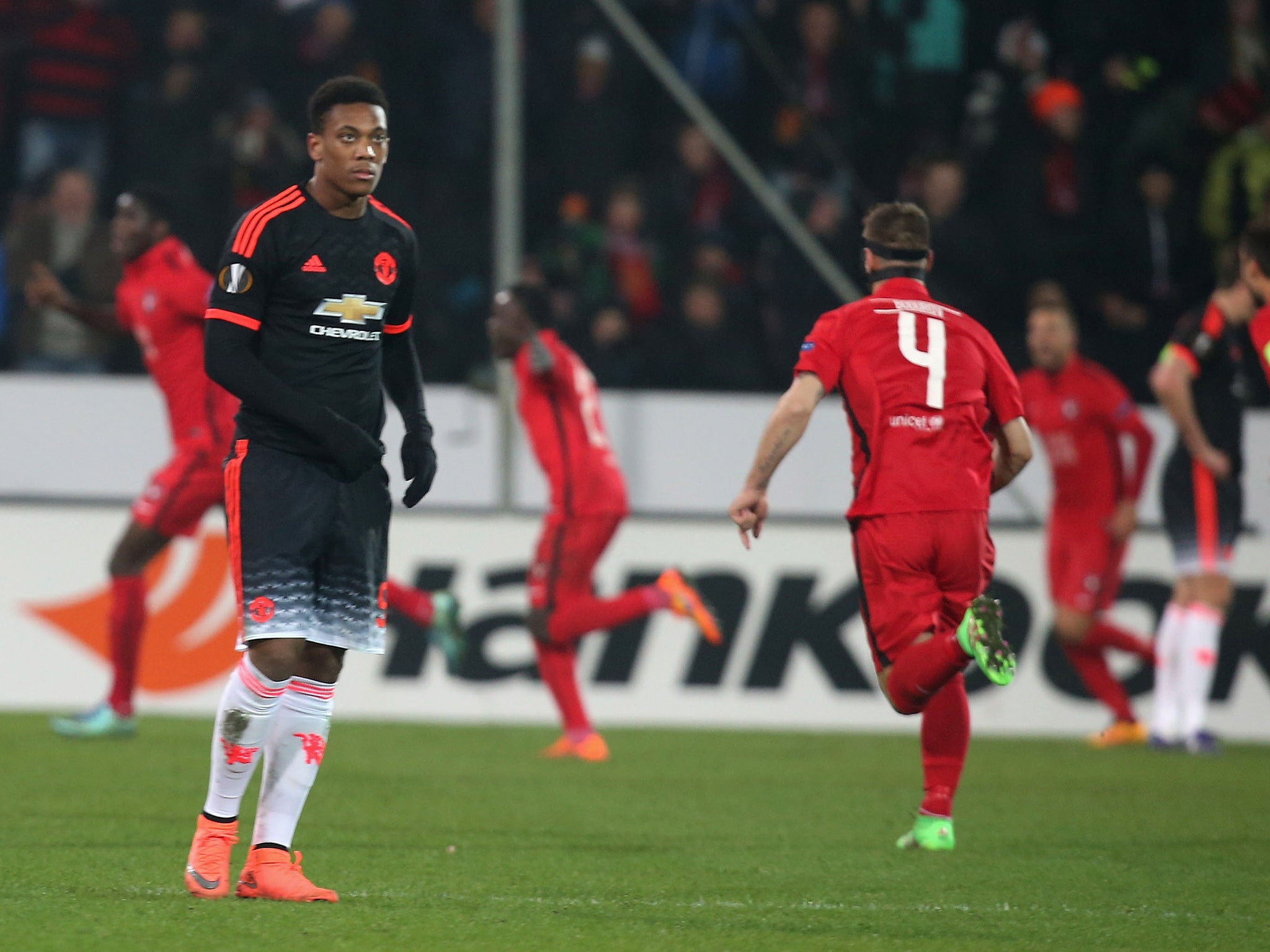 Anthony Martial turns his back as Midtylland's players celebrate their winning goal