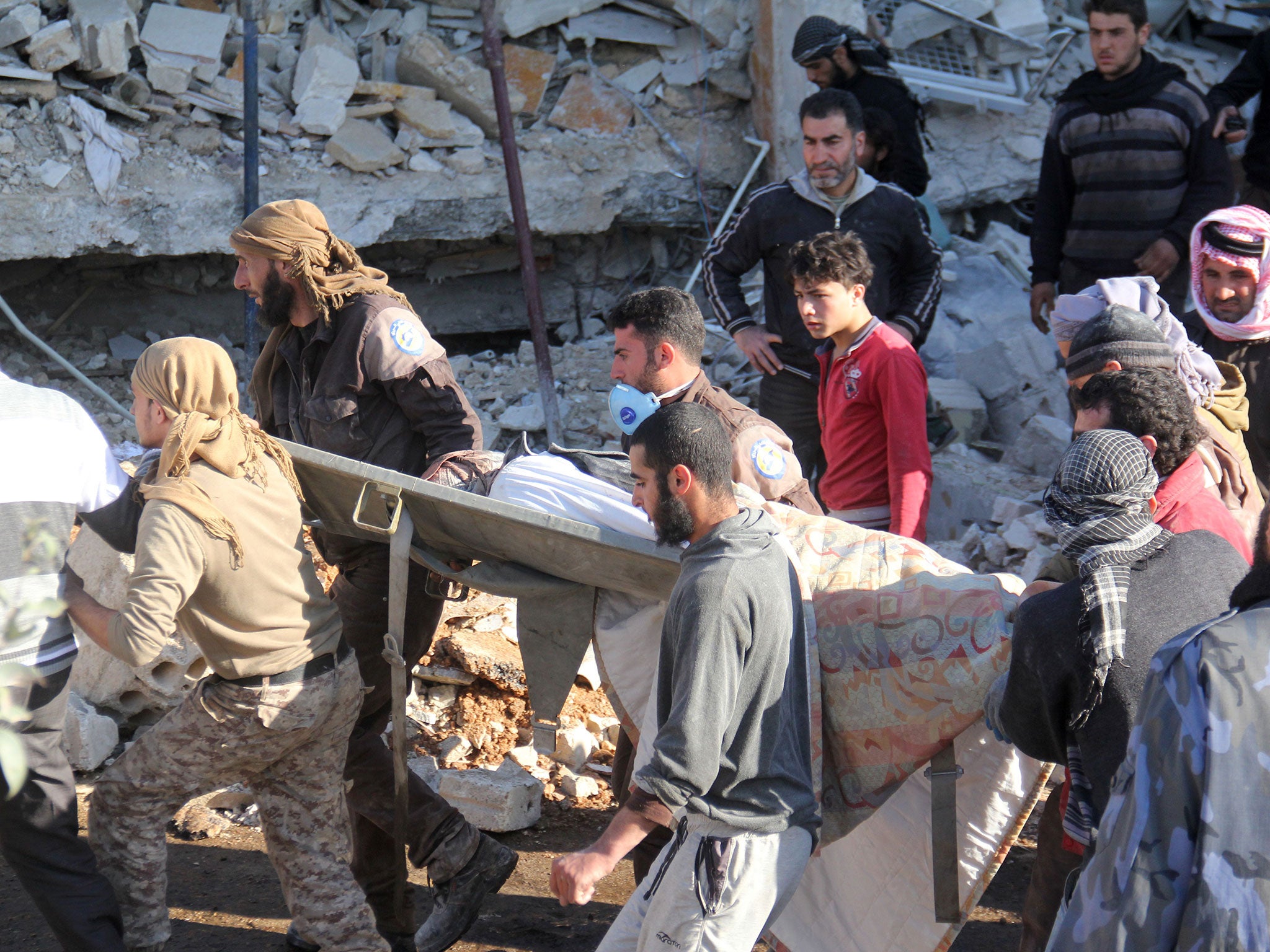 People carry a stretcher amidst debris after a hospital supported by Doctors Without Borders (MSF) was hit by suspected Russian air strikes near Maaret al-Numan, in Syria's northern province of Idlib