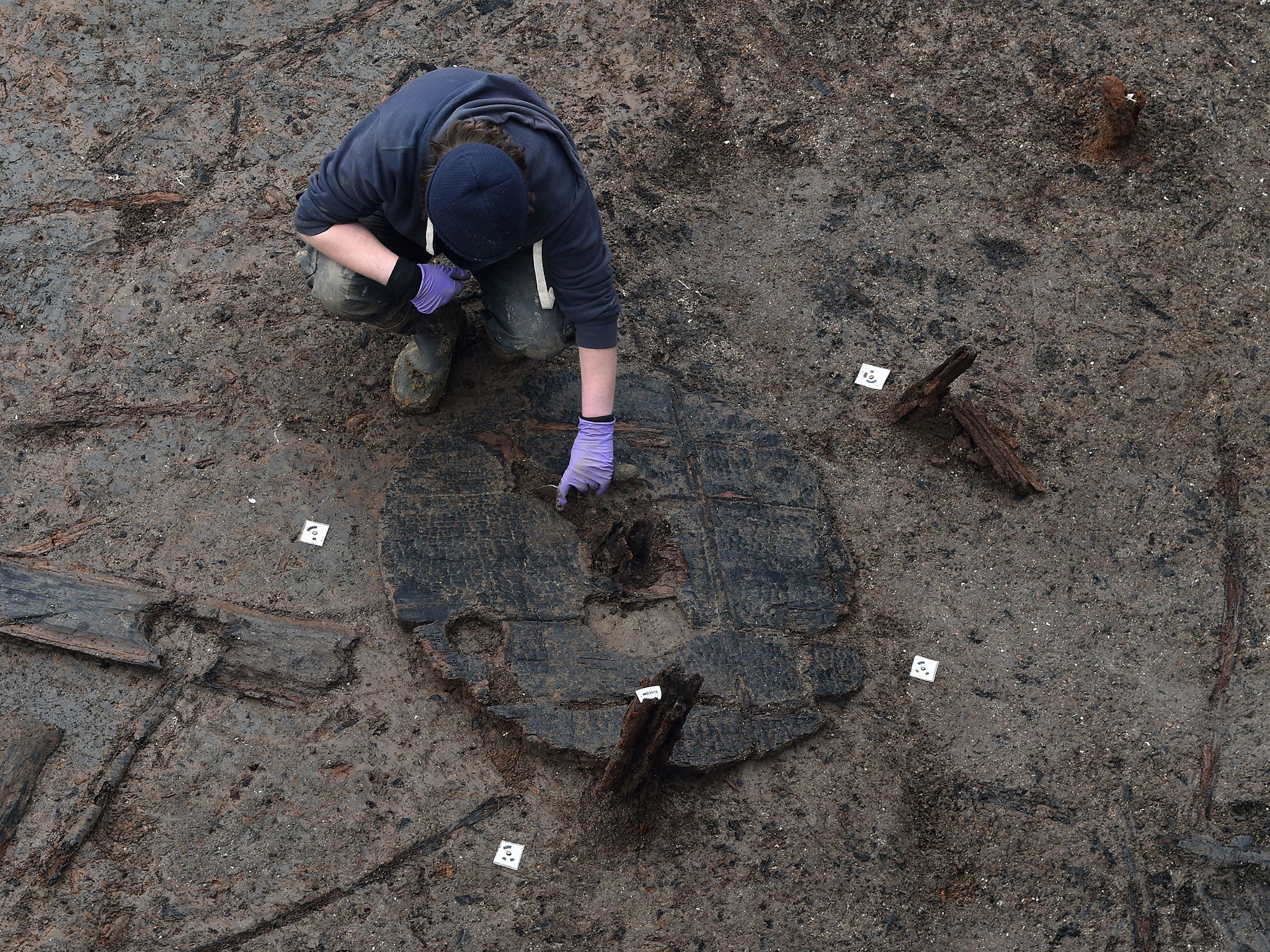 Archaeologists extract the Must Farm wheel from its bed of mud and silt