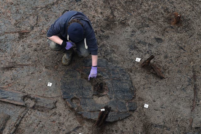 Archaeologists extract the Must Farm wheel from its bed of mud and silt