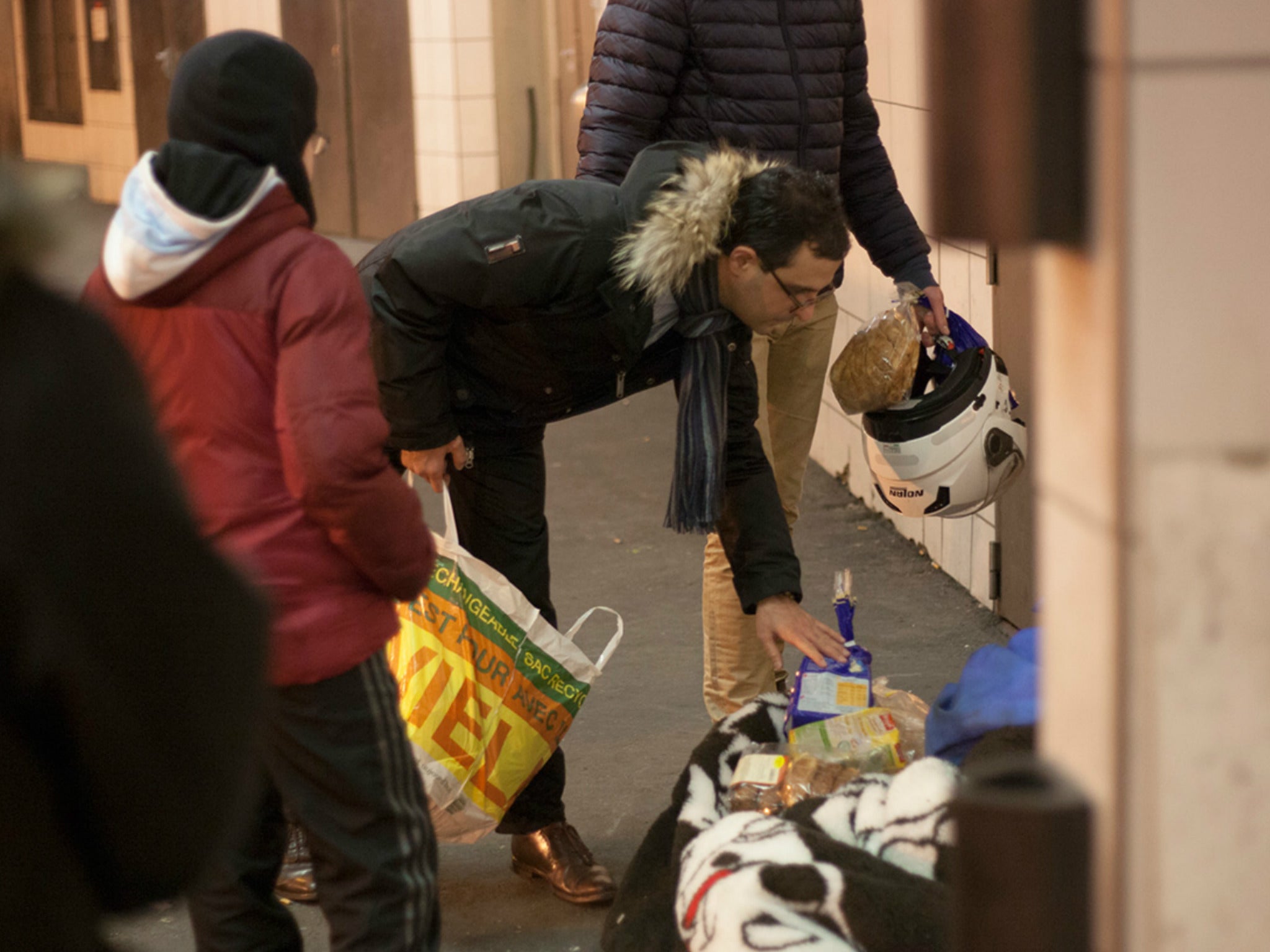 Arash sorts through food at a drop-off point in Courbevoie