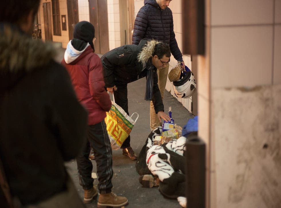 City councillor Aram Derabarsh and others donating food to homeless people in Paris