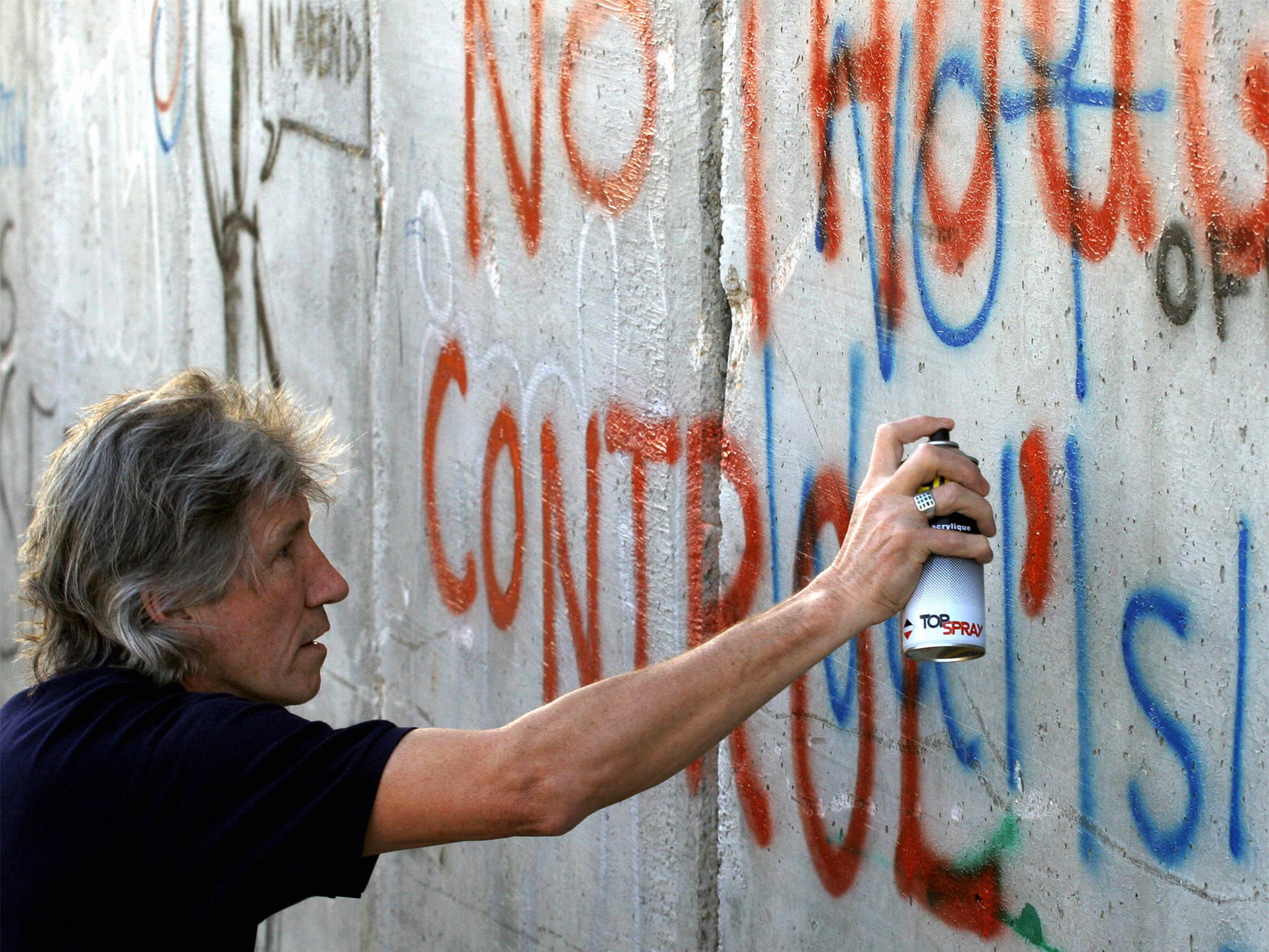 Roger Waters alludes to the band’s lyrics while painting on the Israeli-Palestinian security barrier in Bethlehem in 2006