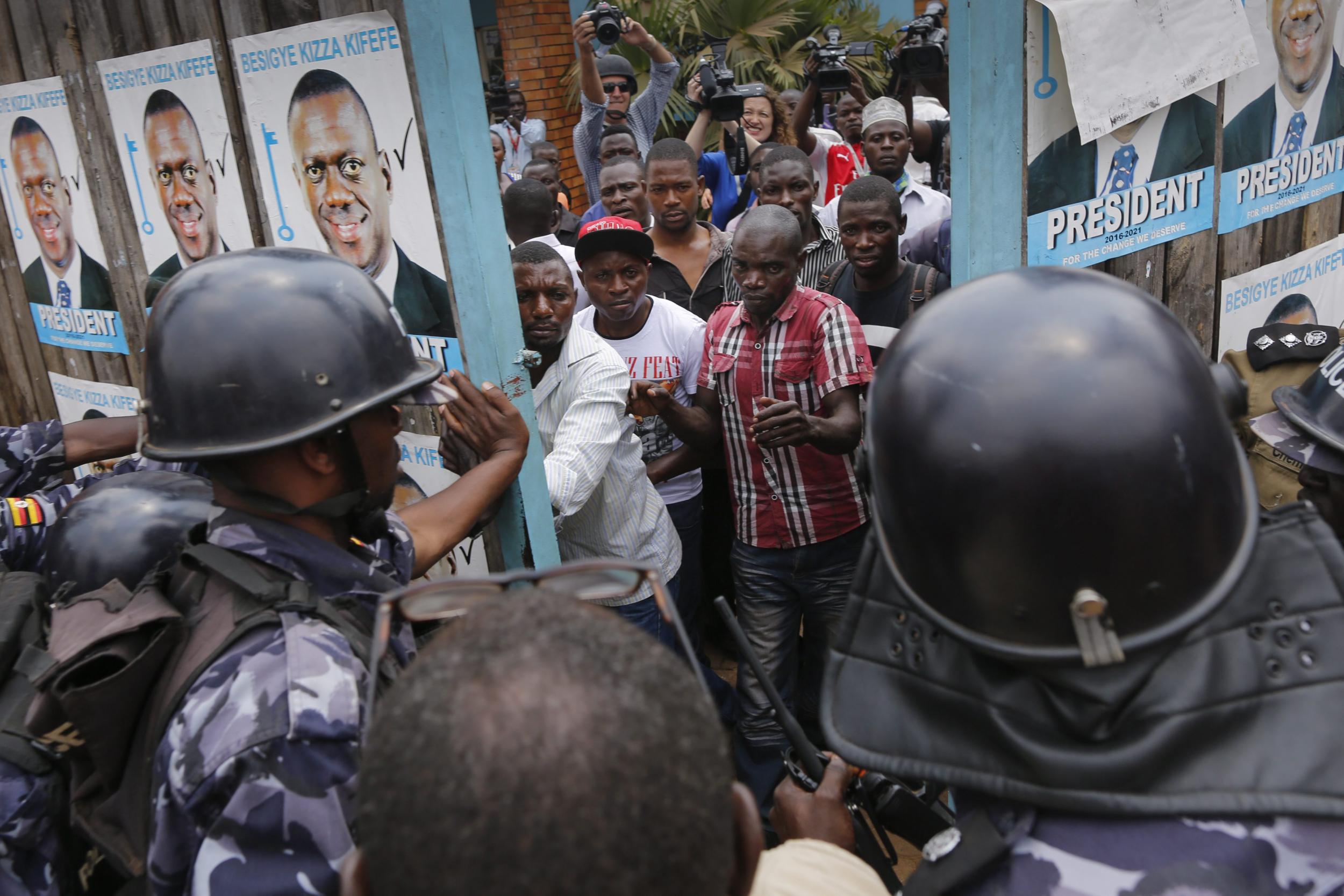 Riot police try to lock supporters of Kizza Besigye, the leader of the main opposition inside Besigye's party headquarters in Kampala