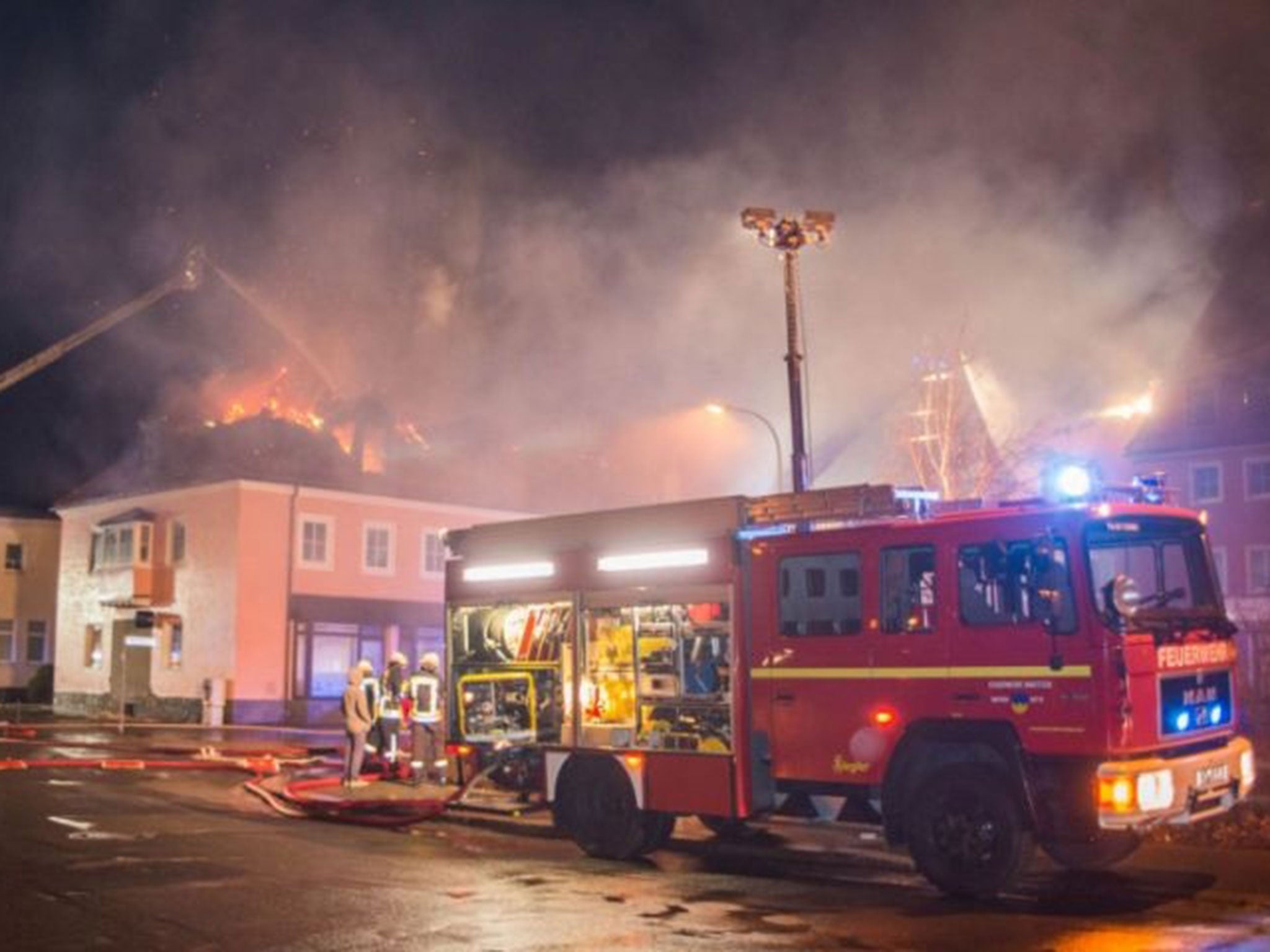 Firefighters tackle a blaze at a refugee shelter in Bautzen, Germany