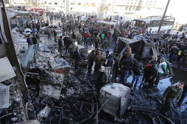 Syrian pro-government forces and residents gather at the site of previous suicide bombings in the area of a revered Shiite shrine in the town of Sayyida Zeinab, on the outskirts of the capital Damascus, on 31 January, 2016