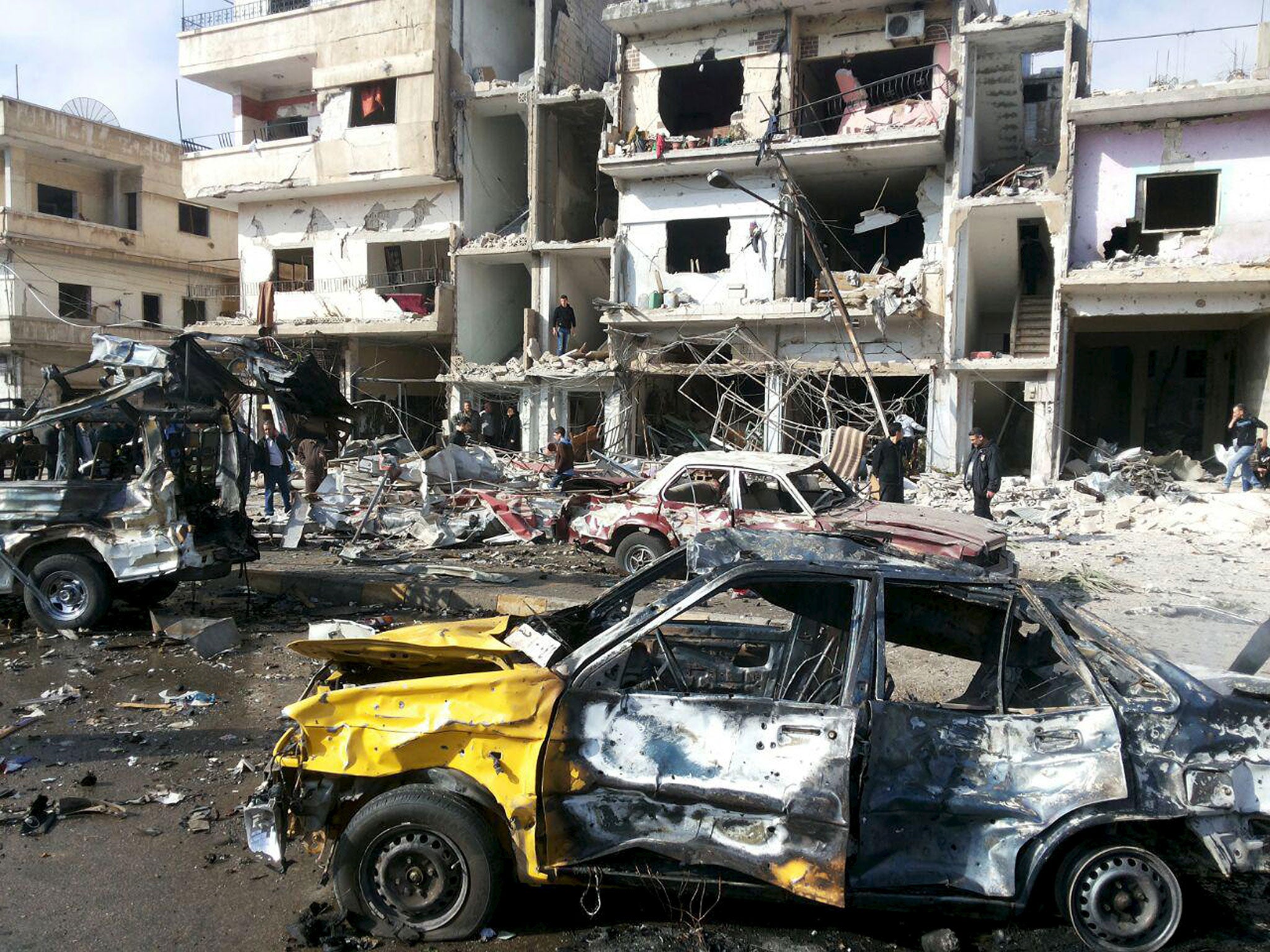 People inspect the site of a two bomb blasts in the government-controlled city of Homs, Syria, on 21 February, 2016