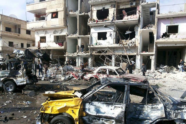 People inspect the site of a two bomb blasts in the government-controlled city of Homs, Syria, on 21 February, 2016