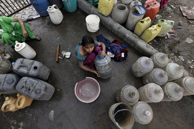 <p>A girl waiting to fill water containers from a municipal tap in Delhi, where the protests have created a shortage</p>