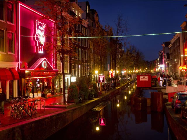 People walk through the red-light district, known as De Wallen, in Amsterdam