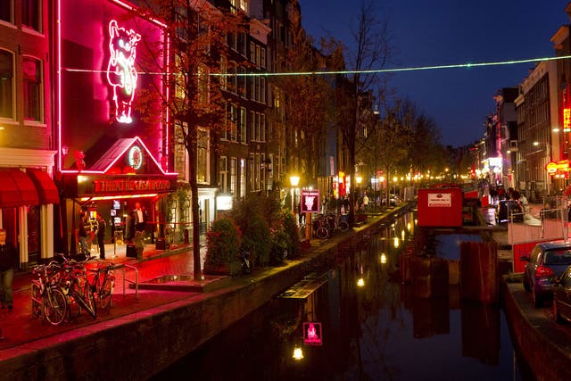 People walk through the red-light district, known as De Wallen, in Amsterdam