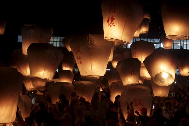 People release sky lanterns ahead of the traditional Chinese Lantern Festival in New Taipei