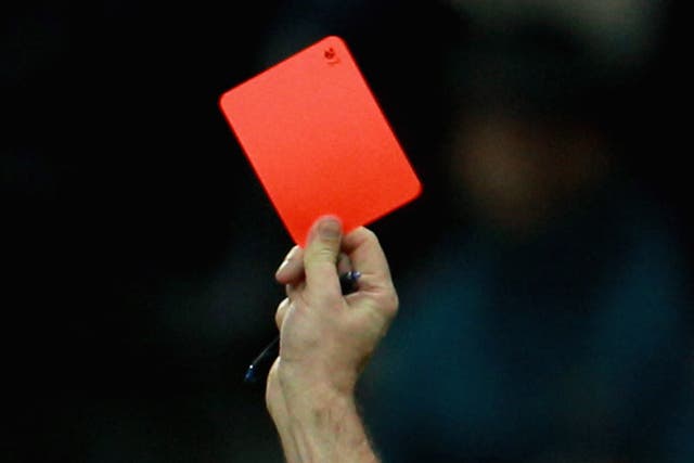 A referee shows a red card