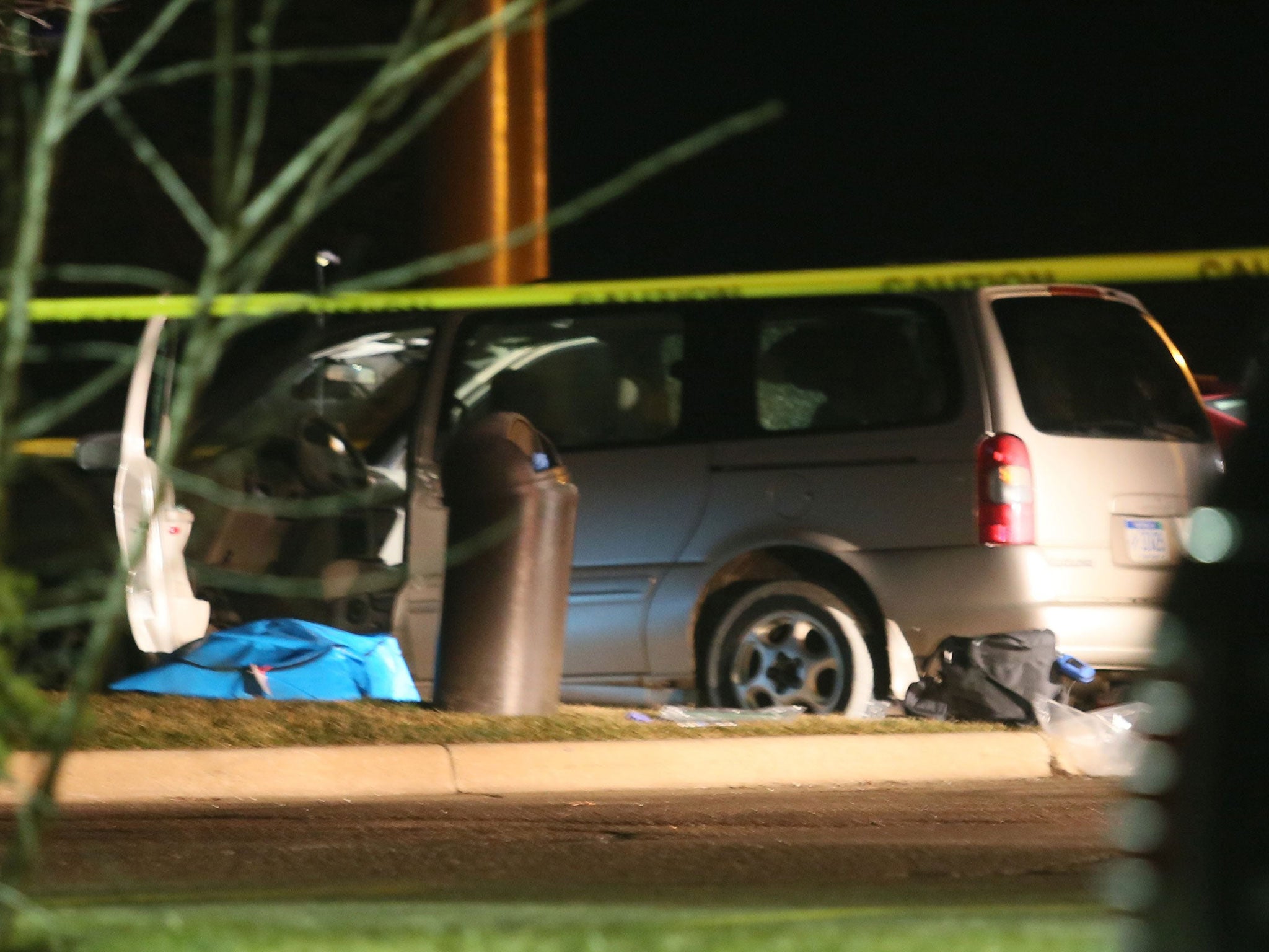 Police investigate the scene of one of the shooting scenes in Kalamazoo