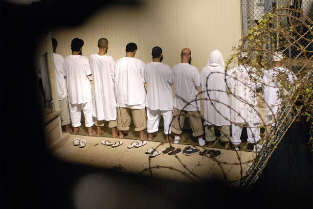 A group of detainees – pictured in 2009 – observing Muslim morning prayer before sunrise at Camp Delta at Guantanamo Bay