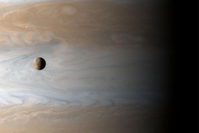 An image of Jupiter with one of its moons, Io, in the foreground, taken by the Cassini probe in 2001
