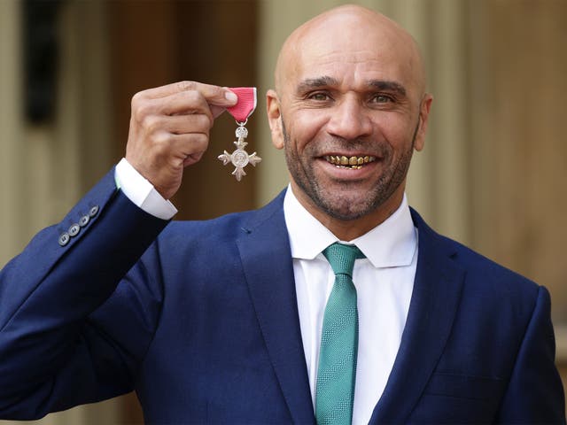 Musician and DJ Goldie, whose real name is Clifford Price, holds his MBE award outside Buckingham Palace