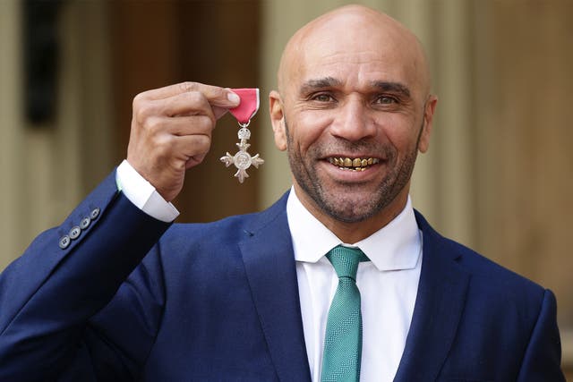 Musician and DJ Goldie, whose real name is Clifford Price, holds his MBE award outside Buckingham Palace
