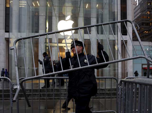 A NYPD officer carries a barrier outside the Apple Store in New York February 23, 2016