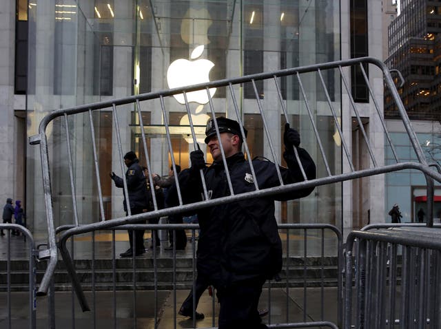 A NYPD officer carries a barrier outside the Apple Store in New York February 23, 2016