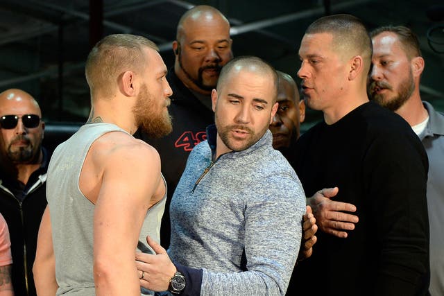 UFC featherweight champion Conor McGregor (L) and lightweight contender Nate Diaz square off ahead of their UFC 196 fight