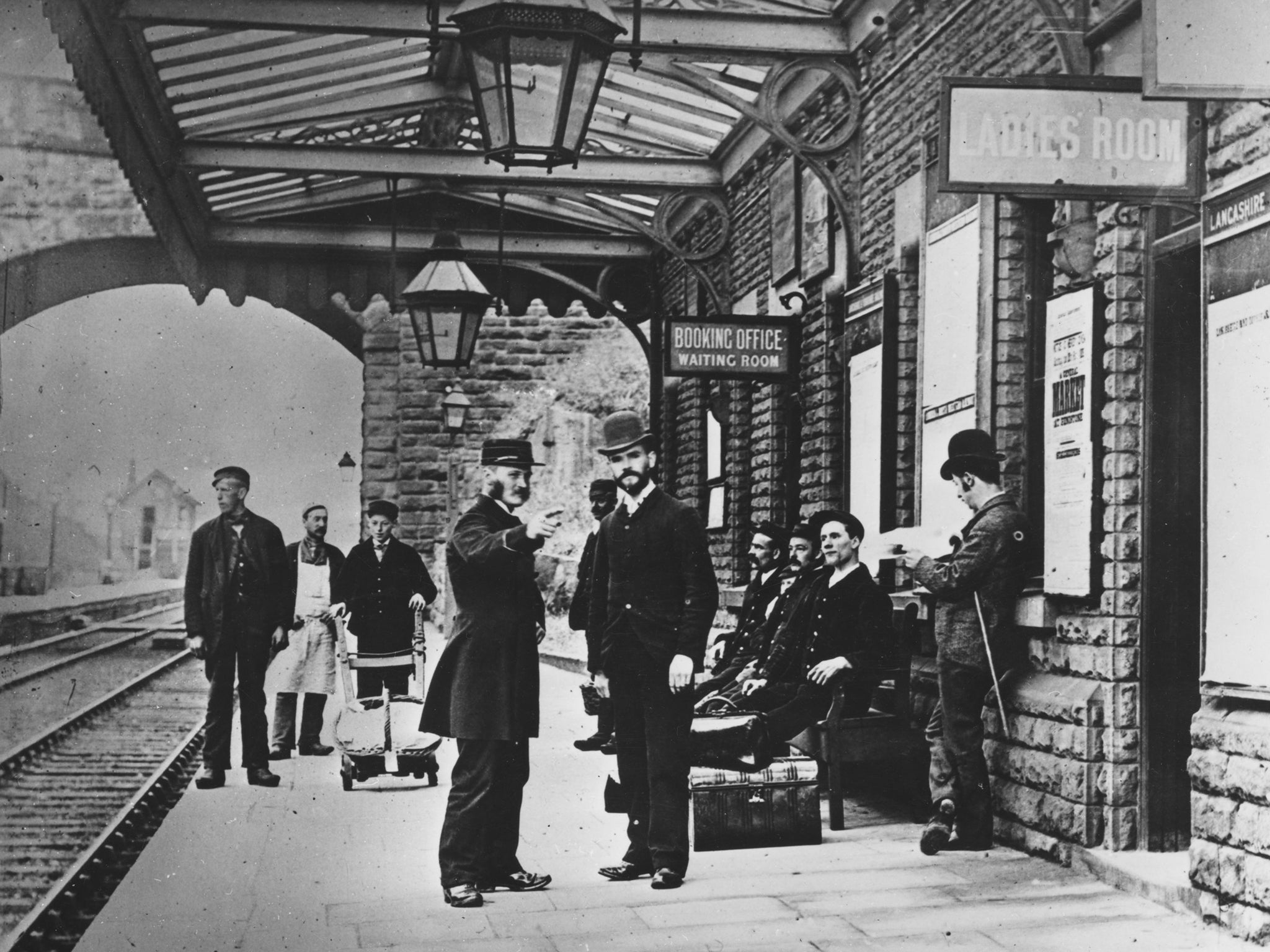 A porter directing a passenger on the platform of a station on the outskirts of Liverpool