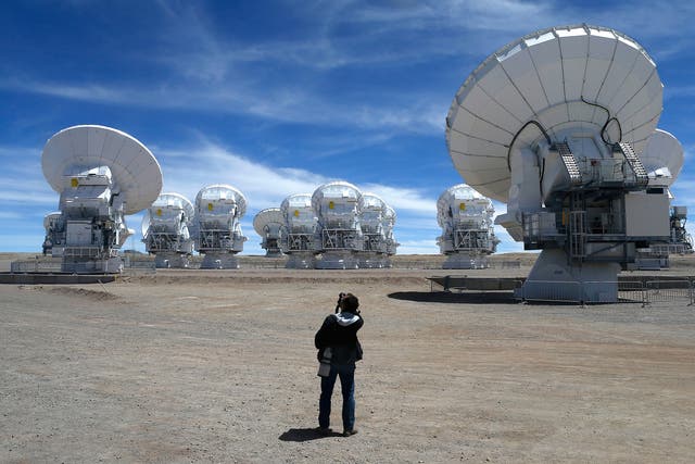 A member of the media takes pictures of the parabolic antennas of the ALMA (Atacama Large Millimetre/Submillimetre Array) project at the El Llano de Chajnantor in the Atacama desert, some 1730 km (1074 miles) north of Santiago and 5000 metres above sea level, March 12, 2013
