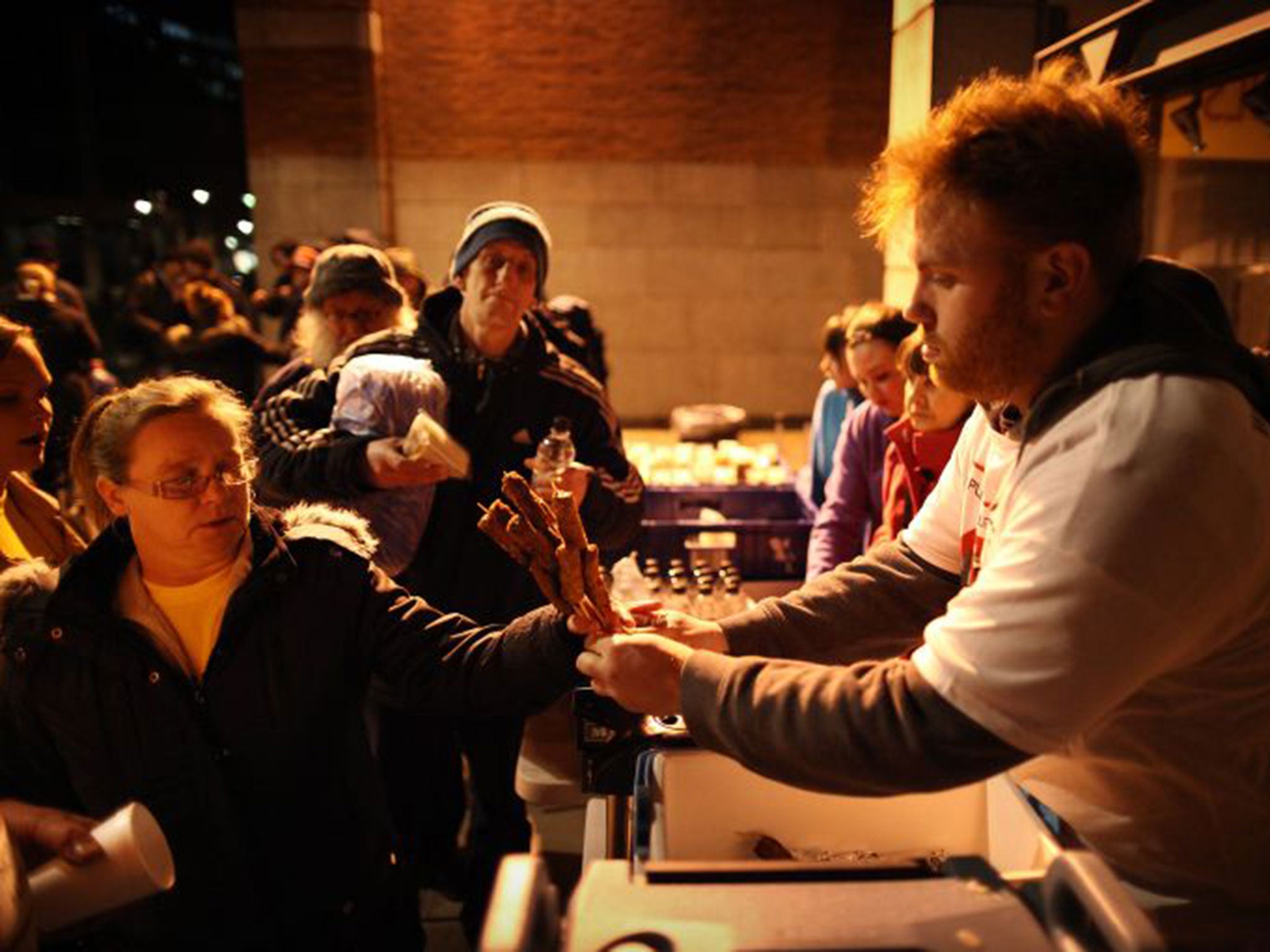 Charity workers distribute food to the homeless next to Westminster Cathedral