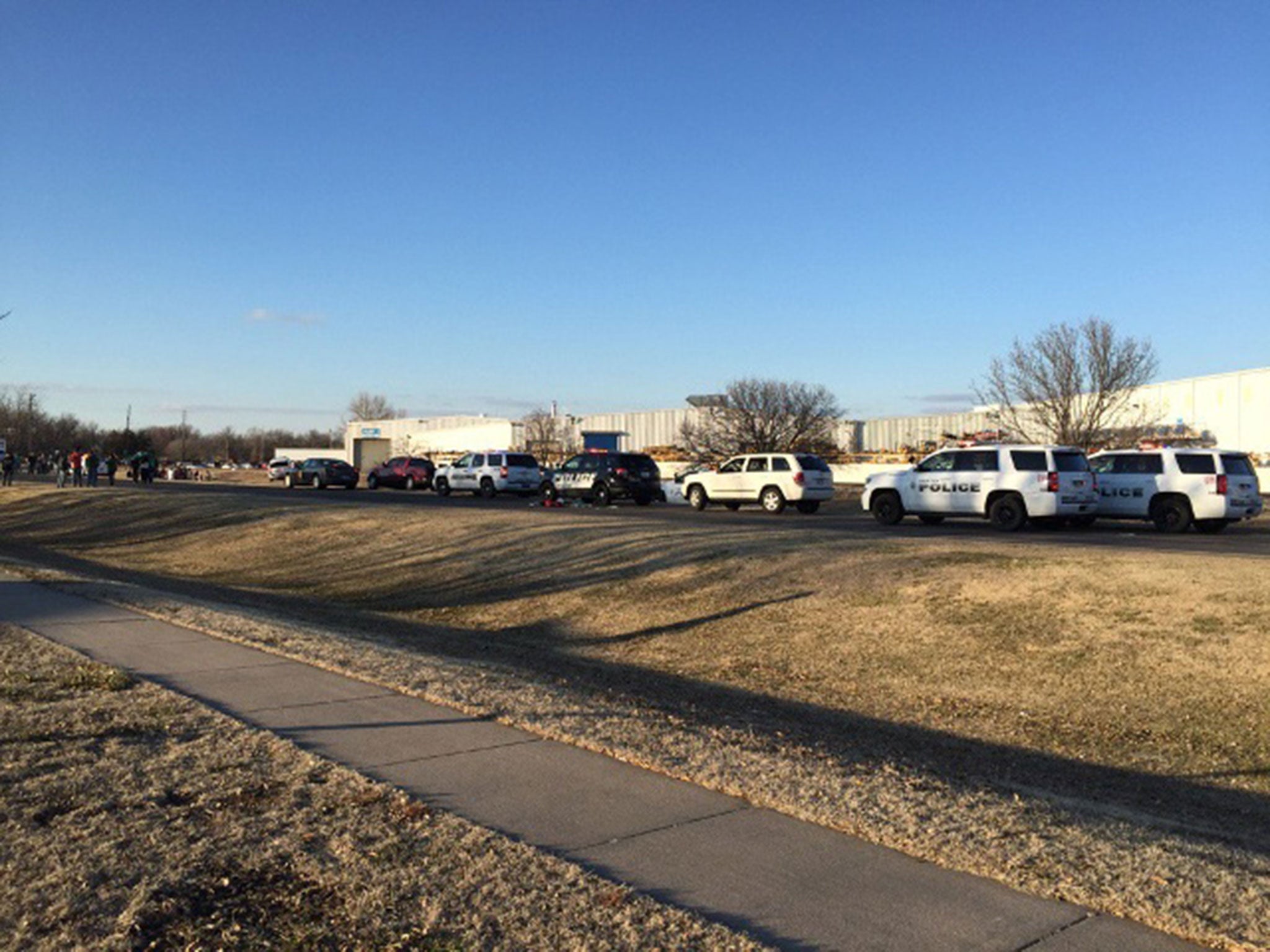Police vehicles line the road after reports of a shooting at an industrial site in Hesston, Kansas