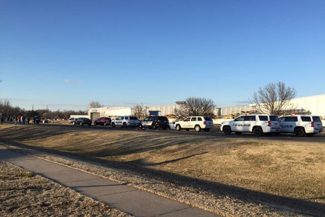 Police vehicles line the road after reports of a shooting at an industrial site in Hesston, Kansas