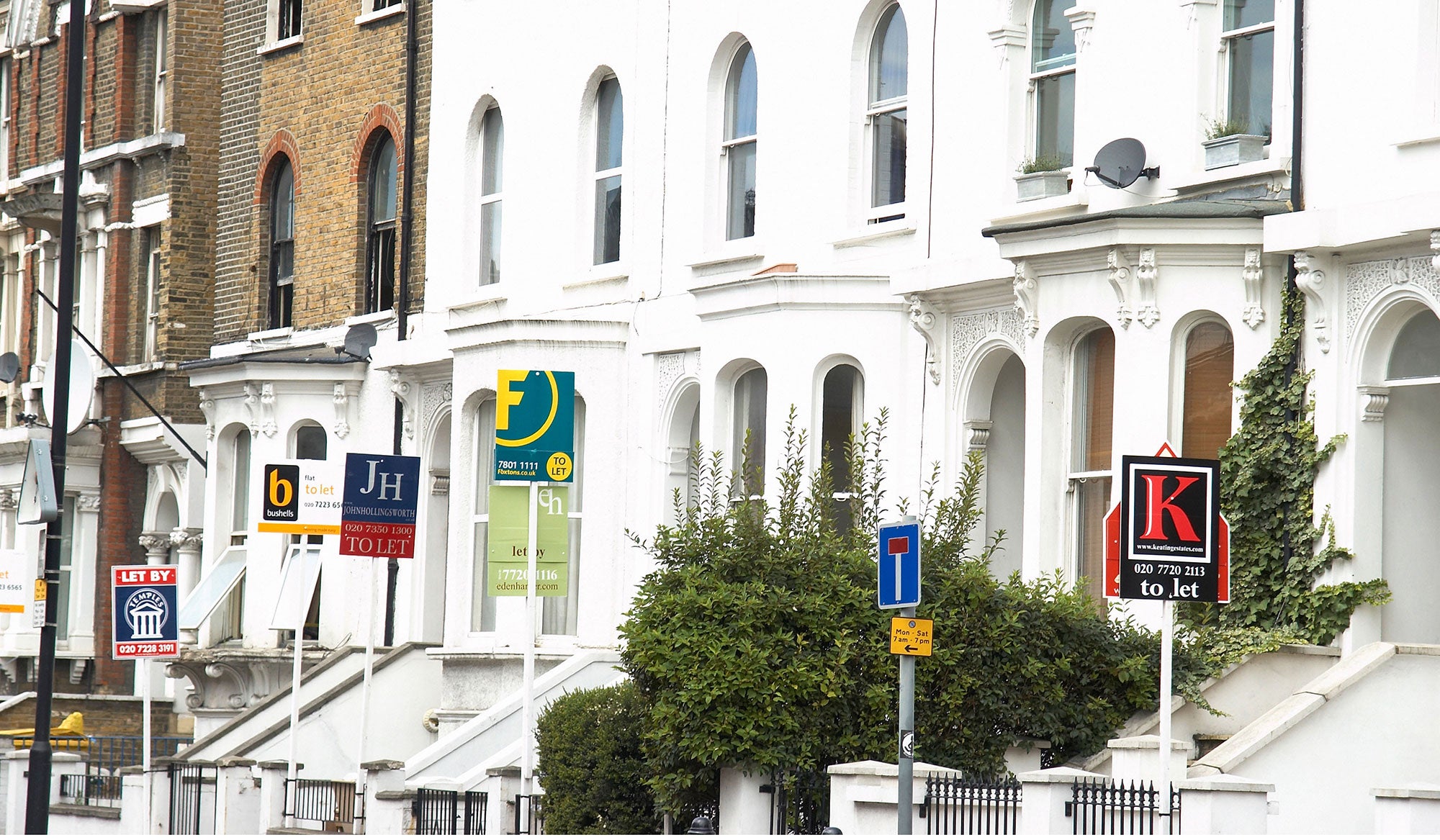 Estate agent signs. House prices in central London are falling, but the commuter belt is becoming more expensive thanks to Crossrail