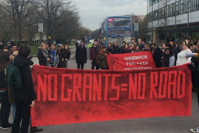 Demonstrators block University Road for half and hour during a day of heated protests against the rising cost of higher education in England