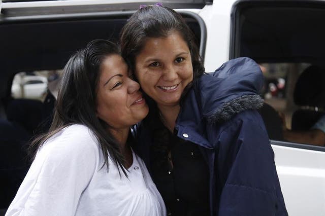 Jacqueline Vasquez Sanchez, left, embraces her sister Lorena Sanchez, right, before a press conference in Bogota, Colombia,