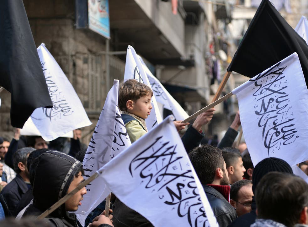 Syrian supporters of the Al-Nusra group wave flags as they march during an anti-regime demonstration