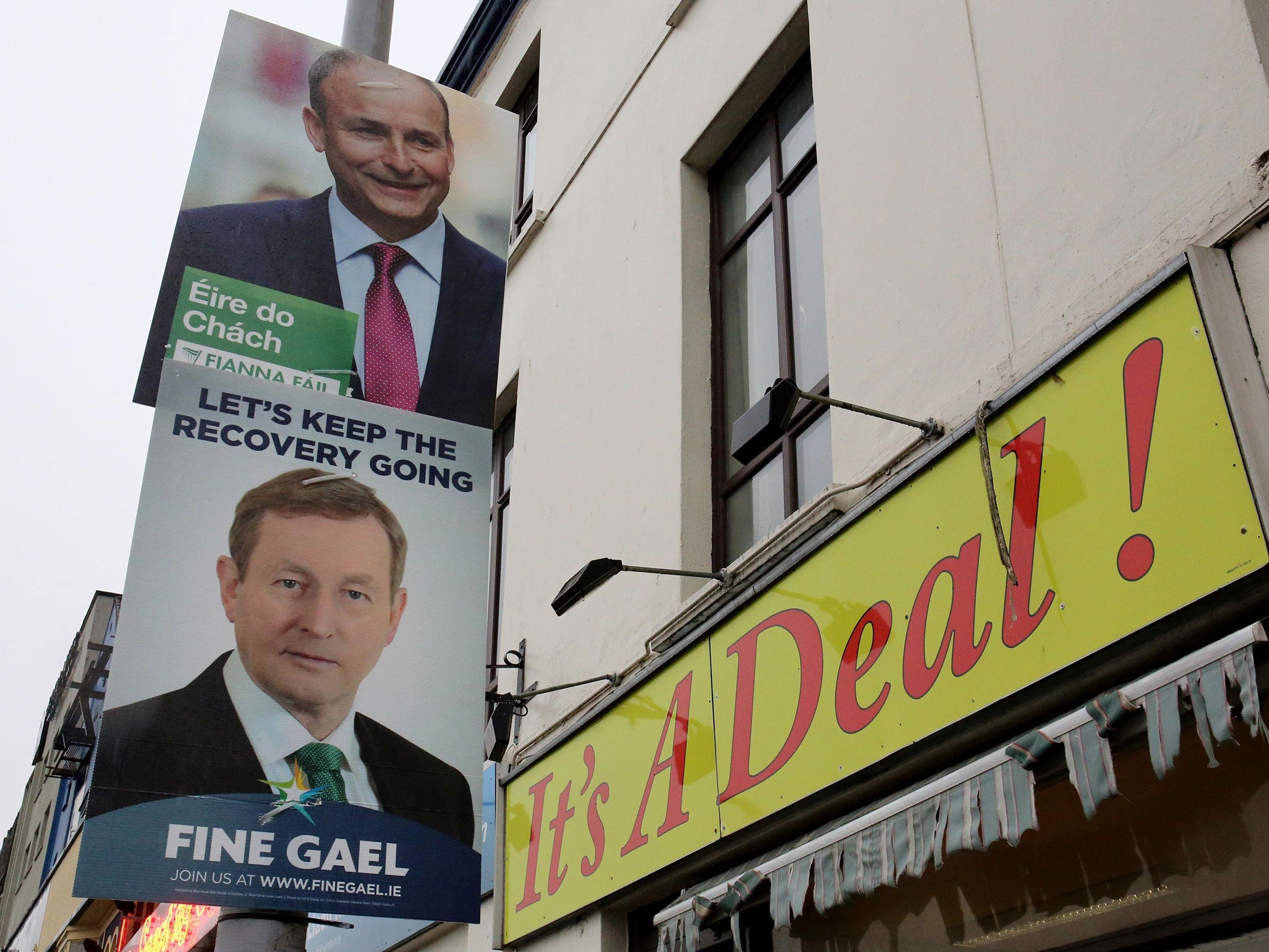 Fianna Fail leader Michael Martin, top, and Fine Gael leader Enda Kenny, on capaign posters in Cork