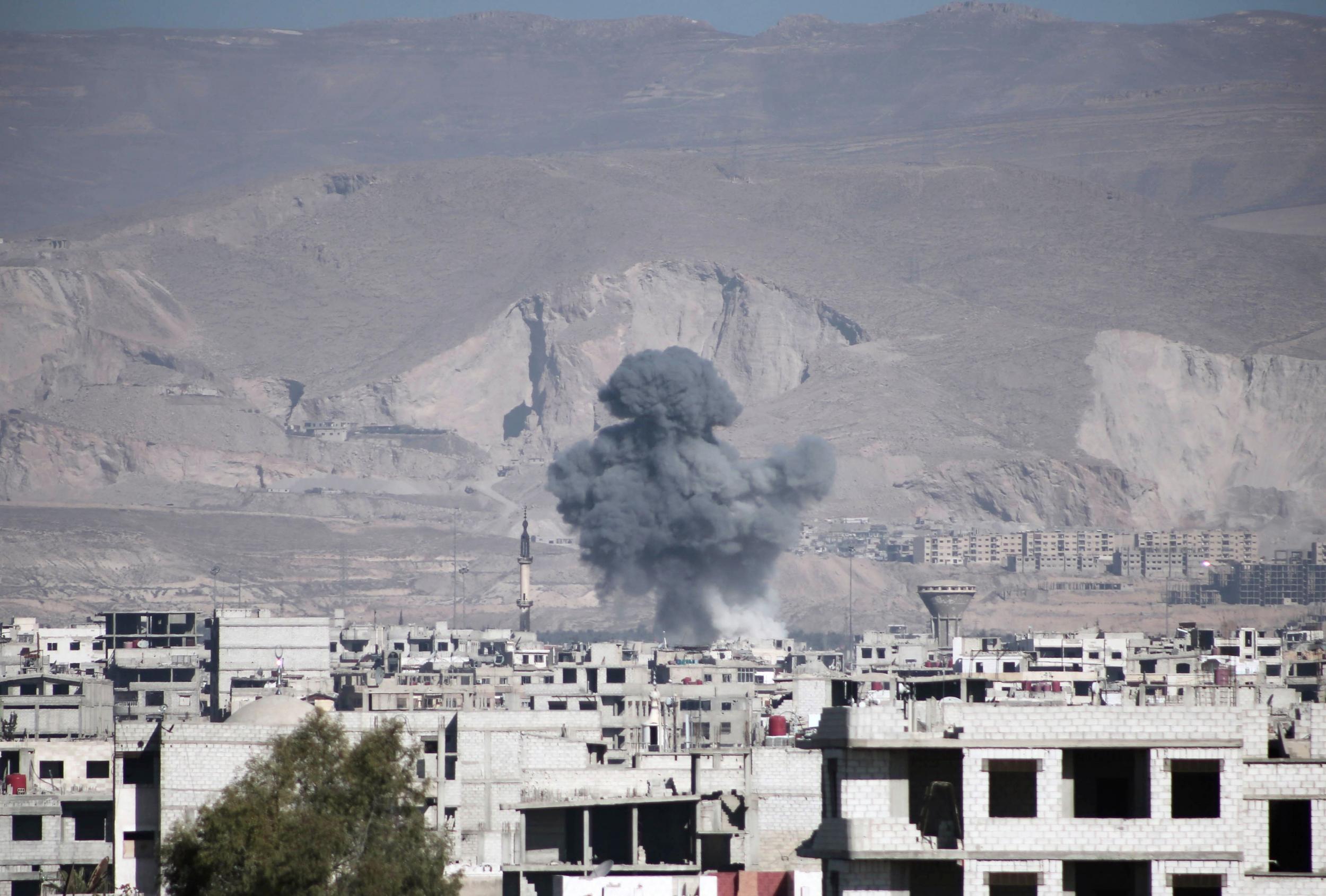 Smoke billows following air strikes in the town, east of the capital Damascus