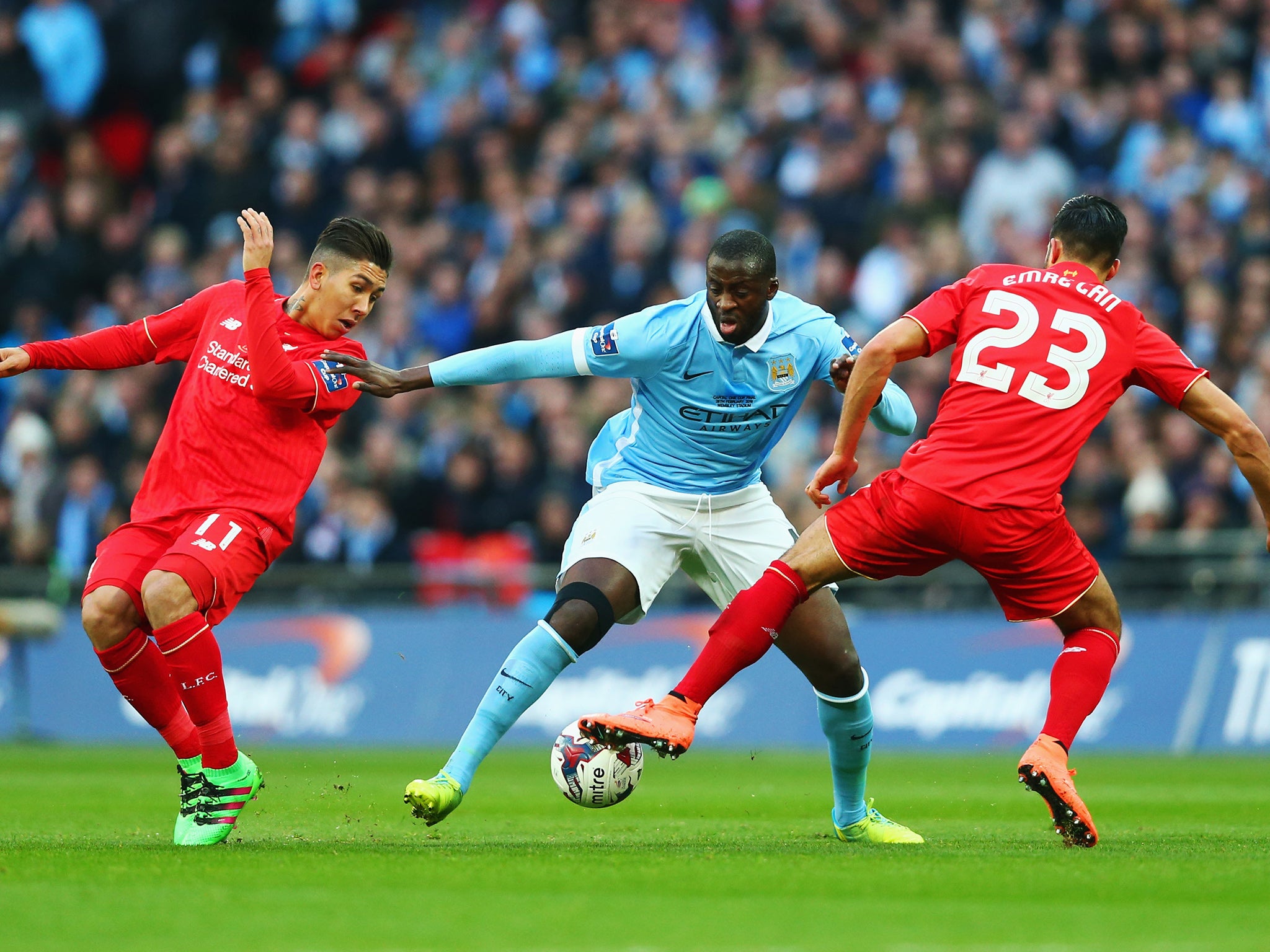 Roberto Firmino and Emre Can attempt to dispossess Yaya Toure